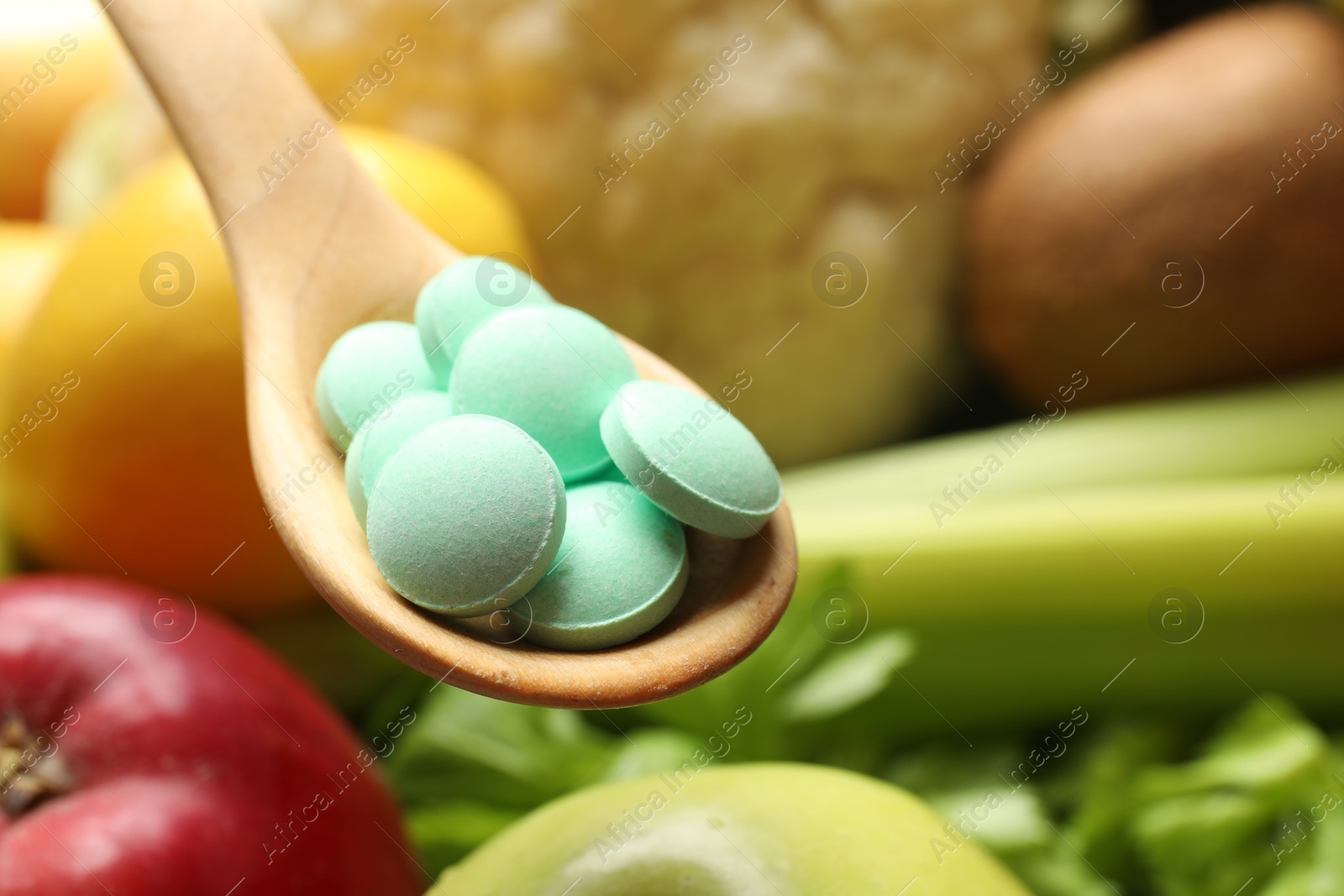 Photo of Dietary supplements. Spoon with pills over food products, closeup. Space for text