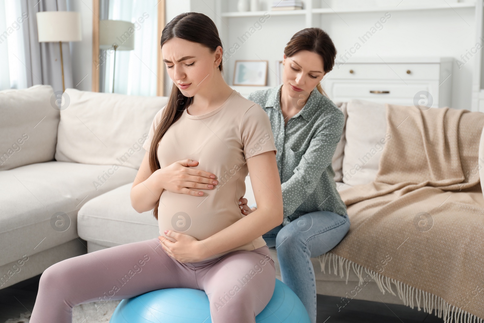 Photo of Doula working with pregnant woman at home. Preparation for child birth