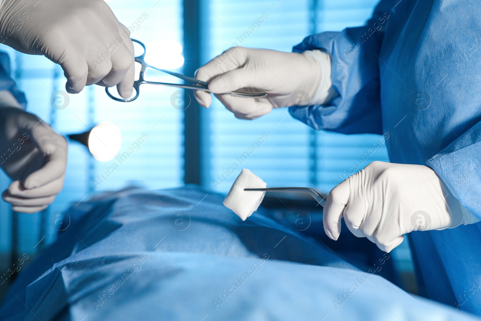 Photo of Professional surgeons with instruments performing operation in clinic, closeup