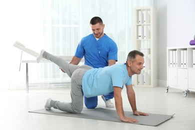 Photo of Doctor working with patient in hospital. Rehabilitation exercises