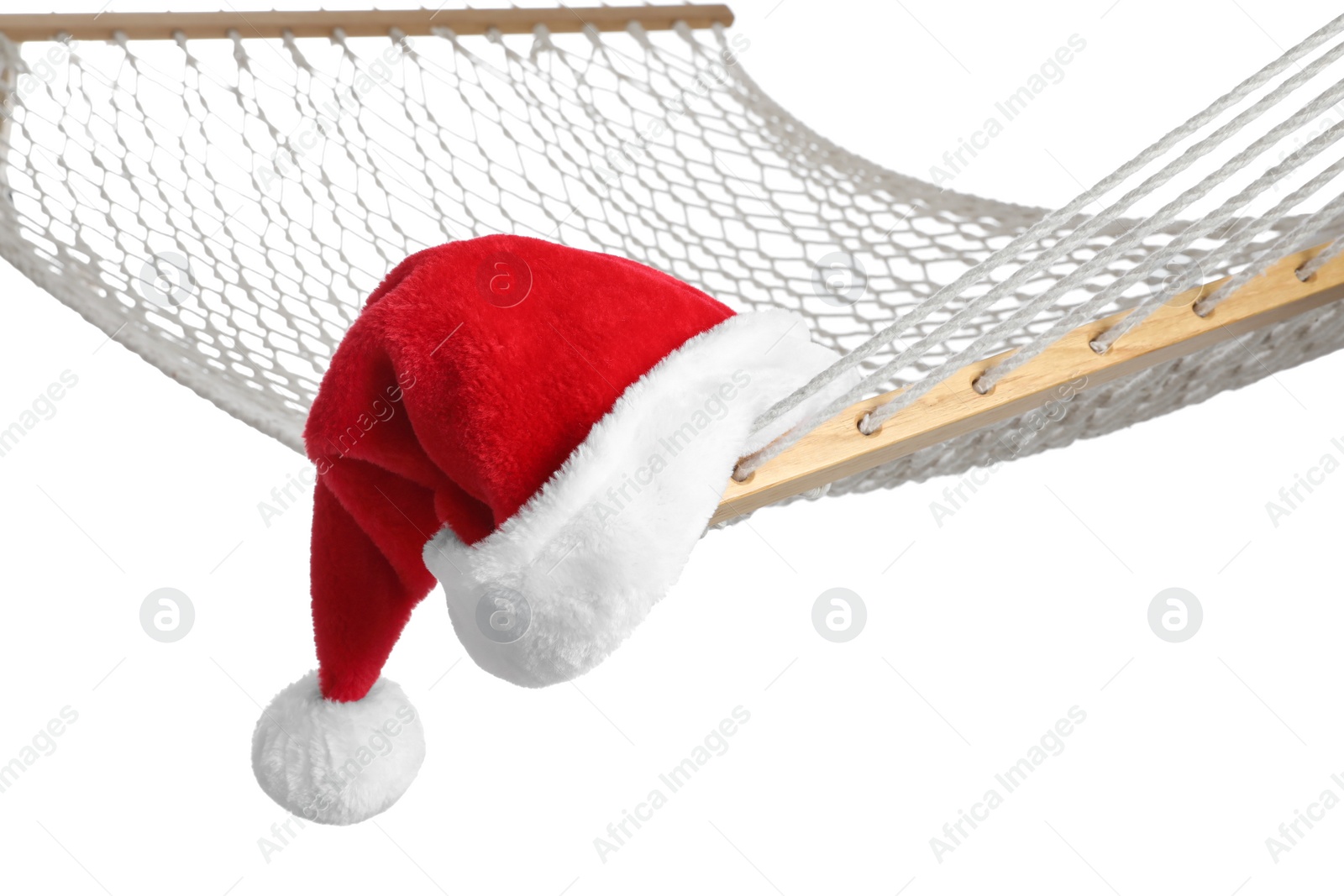 Photo of Comfortable hammock and Santa Claus hat on white background, closeup. Christmas vacation