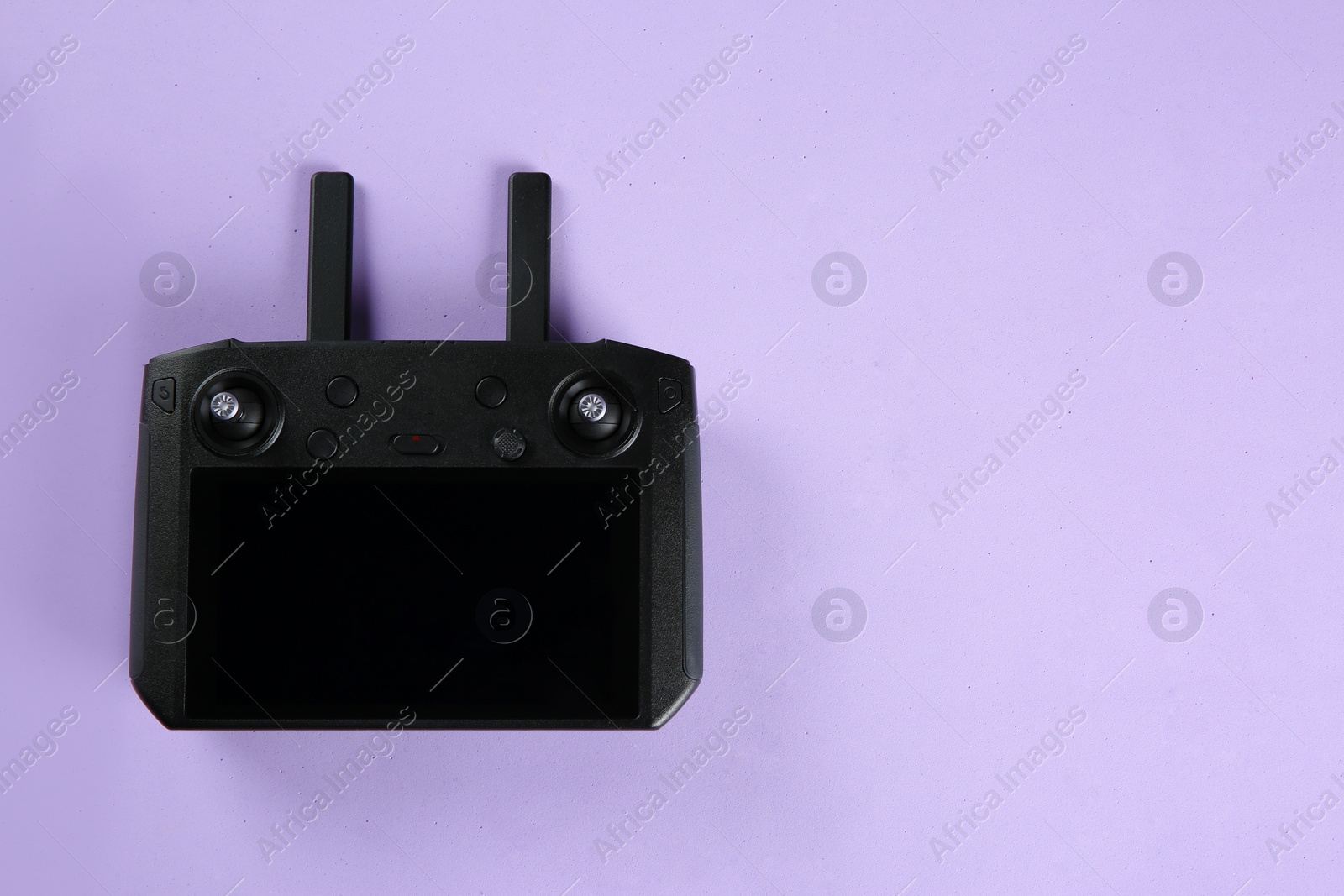 Photo of New modern drone controller on lilac background, top view. Space for text