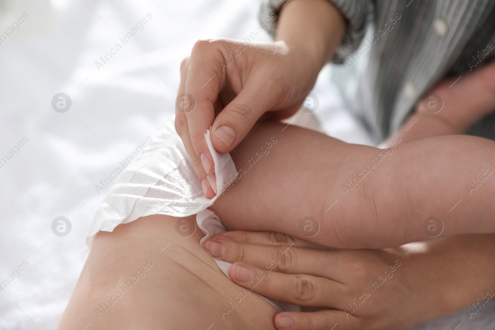 Photo of Mother changing her baby's diaper on table, closeup