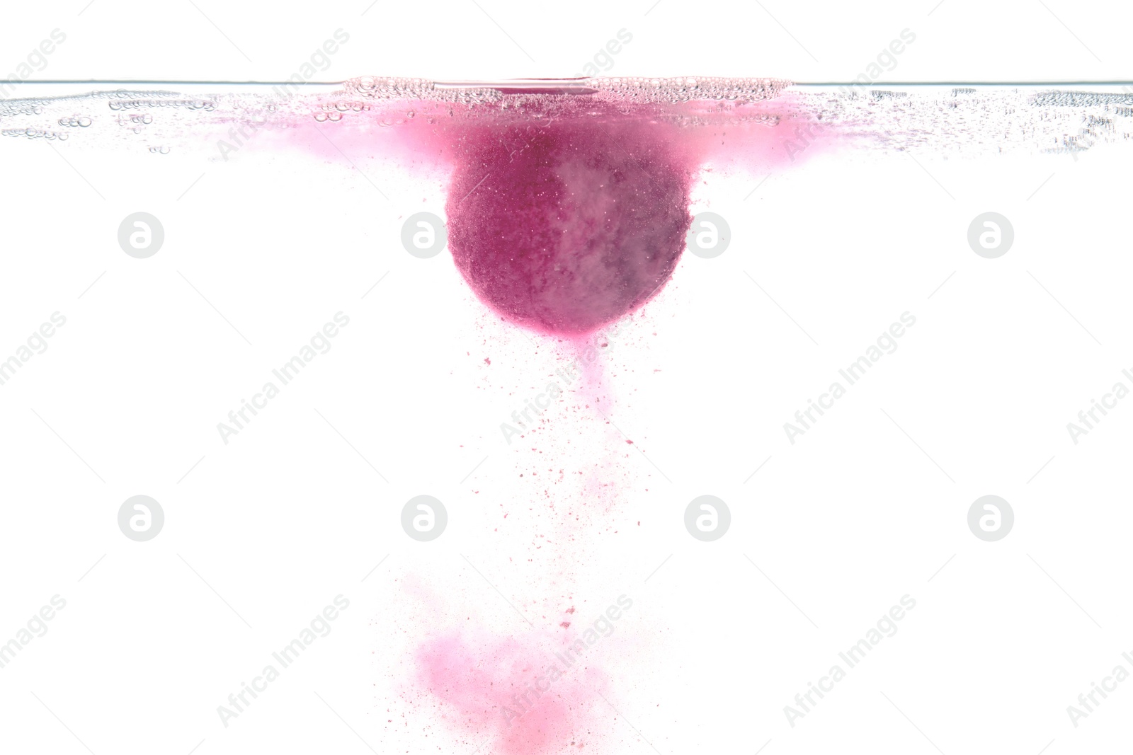 Photo of Pink bath bomb in clear water on white background