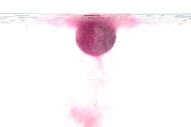 Pink bath bomb in clear water on white background