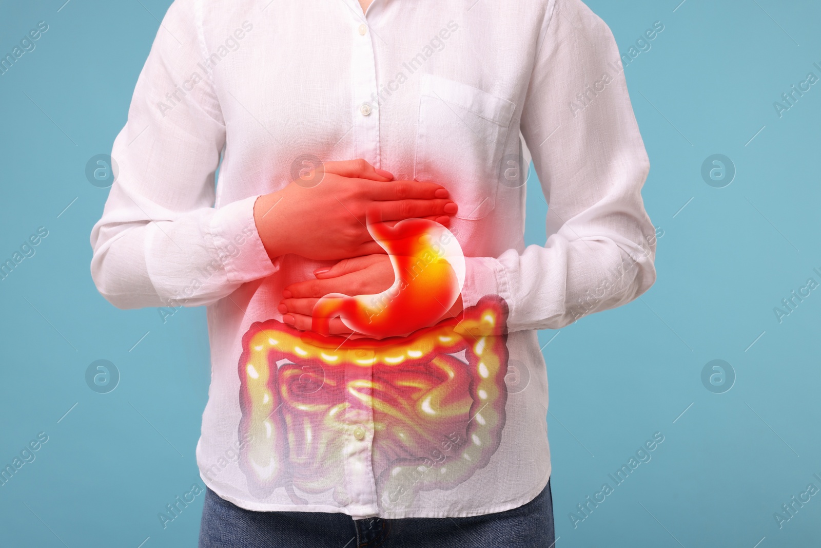 Image of Woman suffering from stomach ache on light blue background, closeup. Illustration of unhealthy gastrointestinal tract