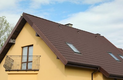 Photo of Modern house with brown roof against blue sky