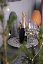 Photo of Glasses and bottle of champagne on table indoors. Interior design