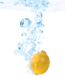Photo of Lemon falling down into clear water against white background