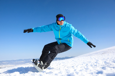 Photo of Man snowboarding on snowy hill. Winter vacation