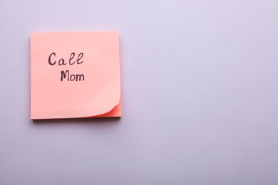 Photo of Paper note with phrase Call mom on light grey background, top view. Space for text