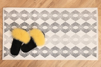 Photo of Soft bath mat and slippers on floor, top view