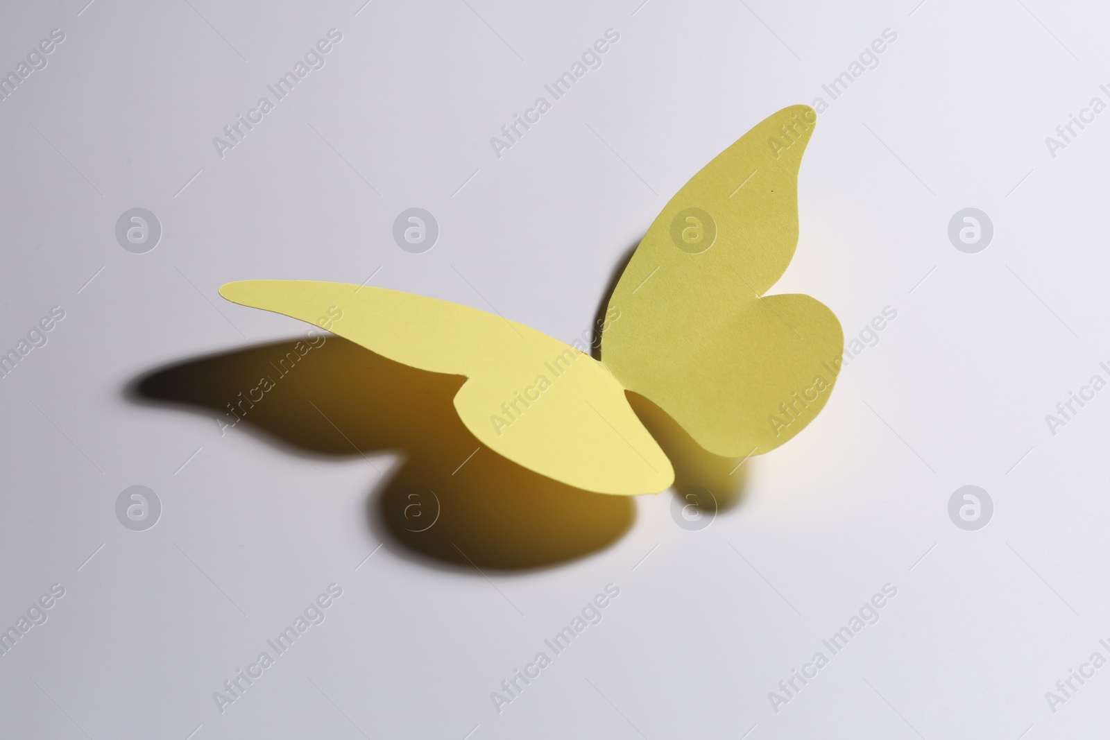 Photo of One yellow paper butterfly on light background