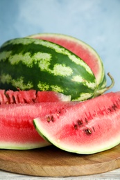 Photo of Yummy watermelon slices on wooden board, closeup