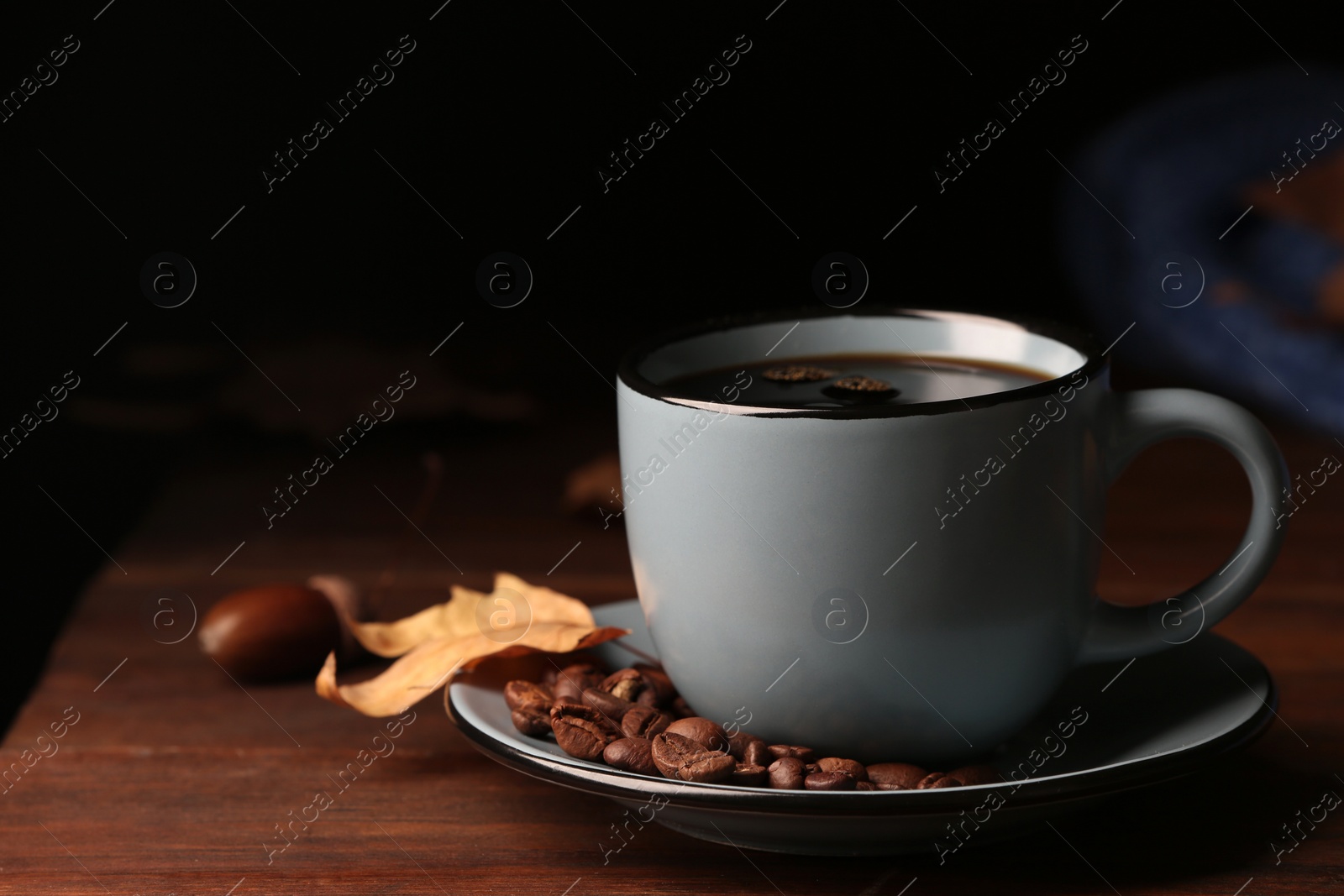 Photo of Composition with cup of hot cozy drink and autumn leaves on table. Space for text