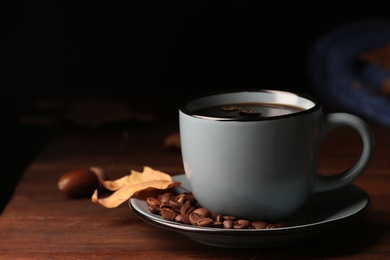 Photo of Composition with cup of hot cozy drink and autumn leaves on table. Space for text