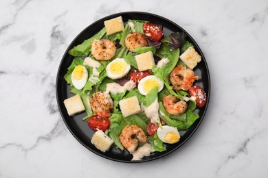 Delicious Caesar salad with shrimps on white marble table, top view