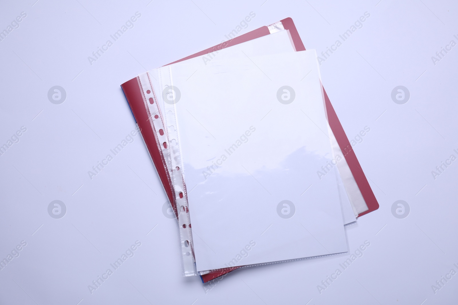 Photo of File folder with punched pockets and paper sheets isolated on white, top view