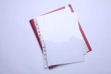 Photo of File folder with punched pockets and paper sheets isolated on white, top view