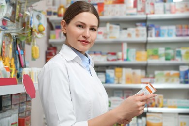 Professional pharmacist with medicine in modern drugstore