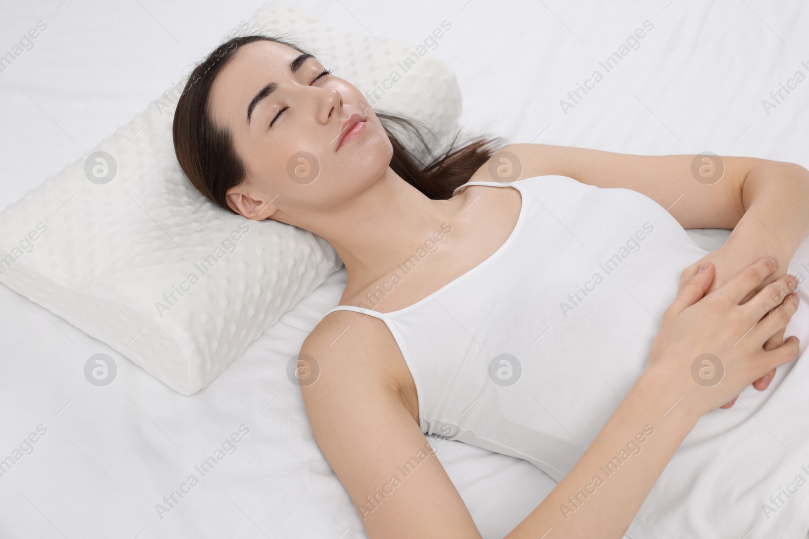 Photo of Woman sleeping on orthopedic pillow in bed