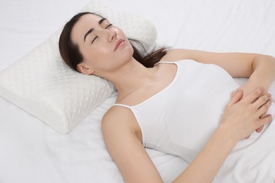 Woman sleeping on orthopedic pillow in bed