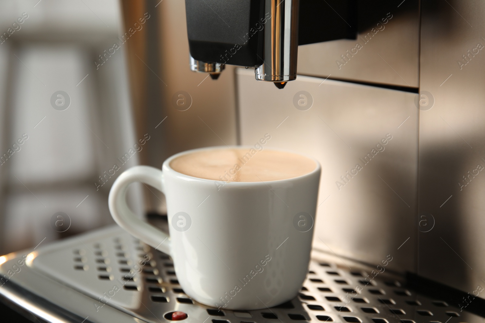 Photo of Espresso machine with cup of fresh coffee on drip tray against blurred background, closeup