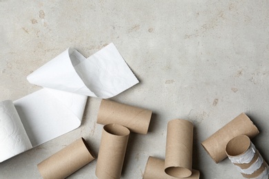 Photo of Flat lay composition with toilet paper and empty rolls on grey background. Space for text