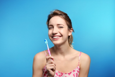 Photo of Portrait of young woman with toothbrush on color background