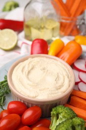 Photo of Plate with delicious hummus and fresh vegetables, closeup