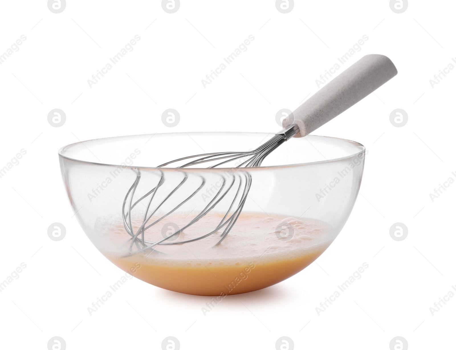 Photo of Beaten eggs and whisk in glass bowl isolated on white