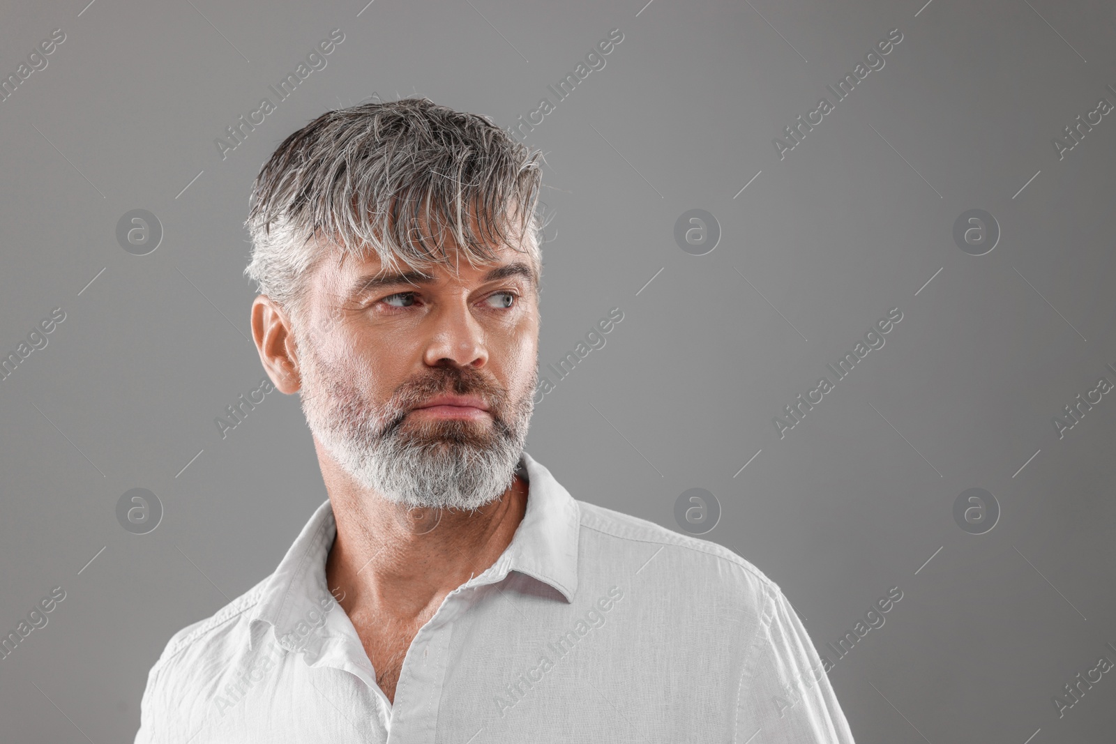 Photo of Portrait of confident man with beautiful hairstyle on light grey background. Space for text