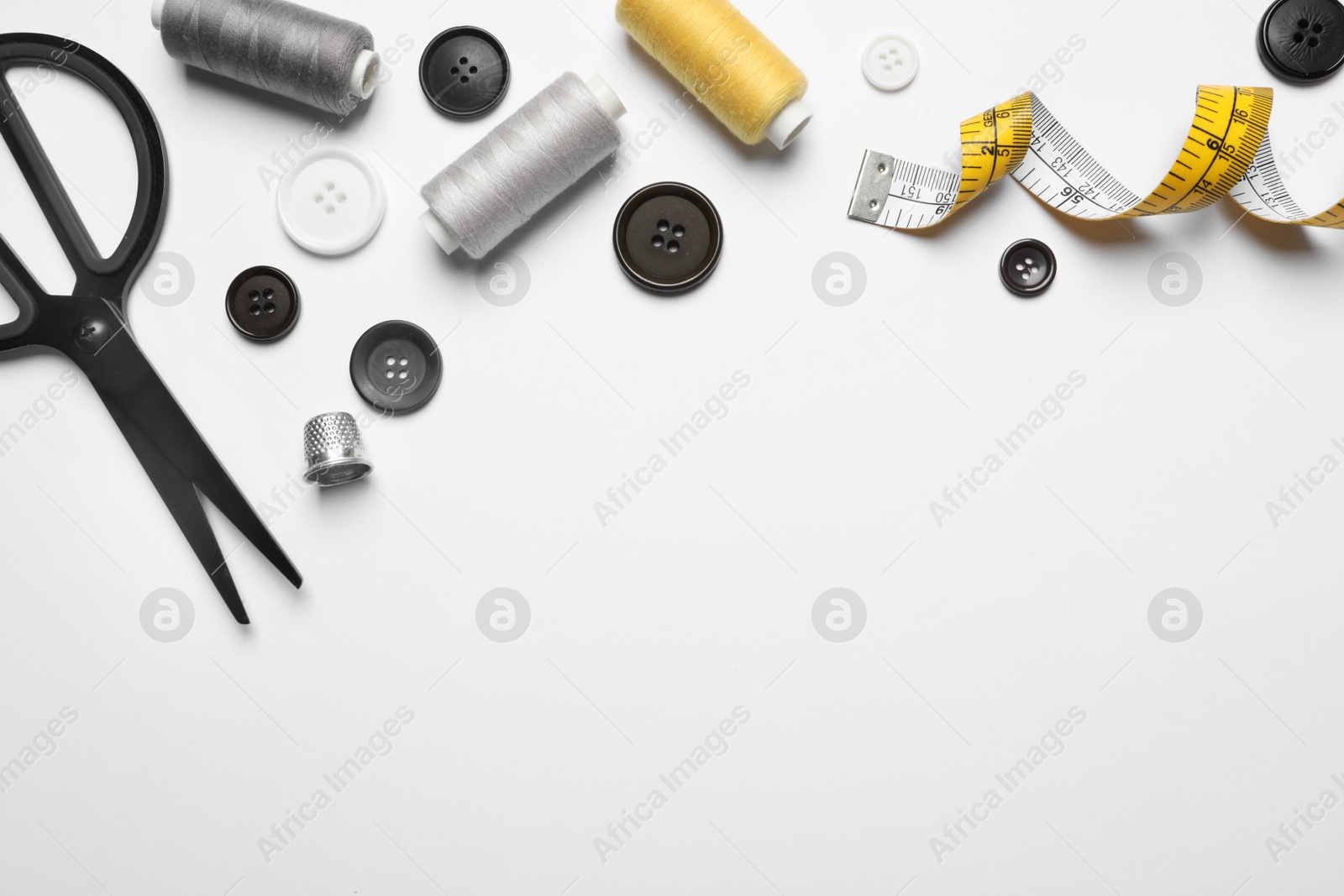 Photo of Composition with scissors and other sewing accessories on white background, top view