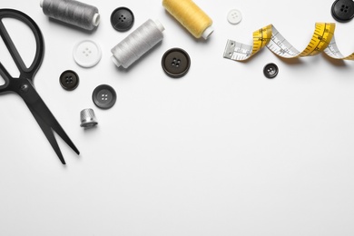 Photo of Composition with scissors and other sewing accessories on white background, top view