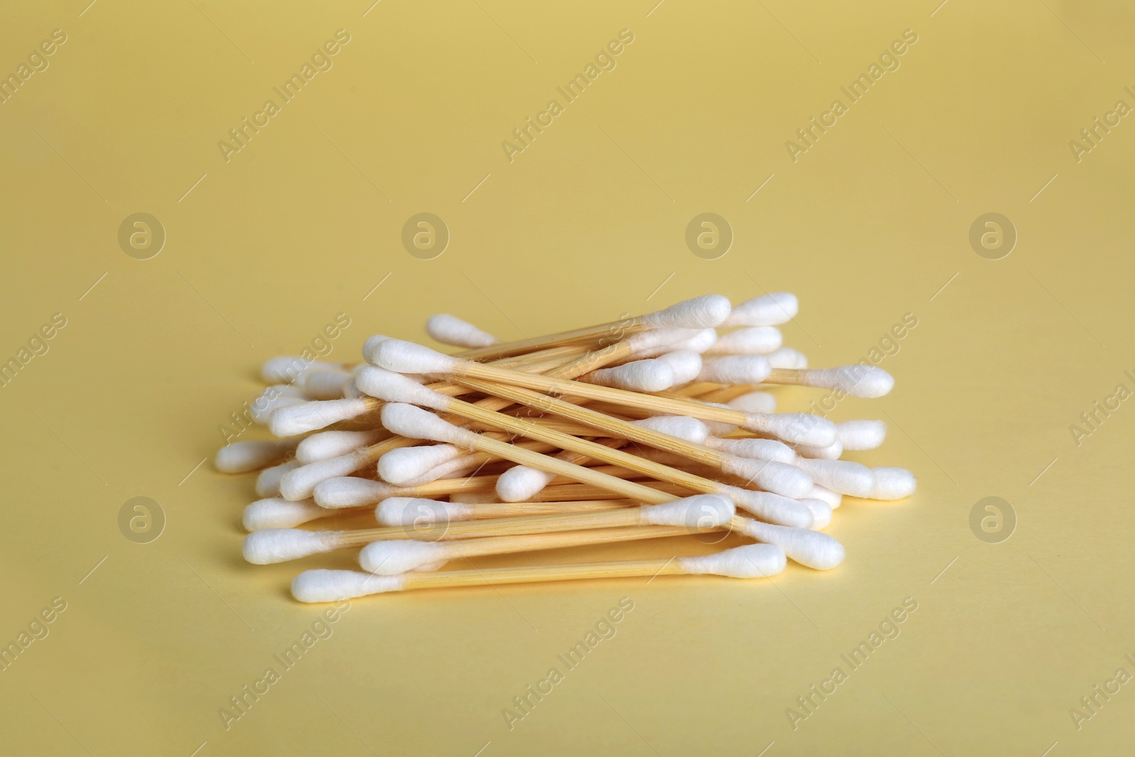 Photo of Many wooden cotton buds on beige background