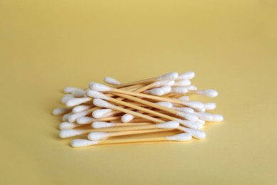 Photo of Many wooden cotton buds on beige background