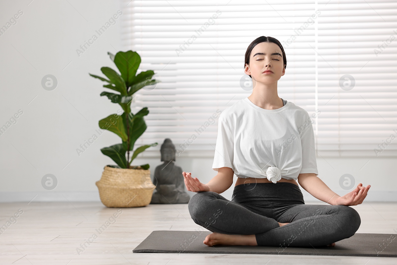 Photo of Beautiful girl meditating on mat in yoga studio