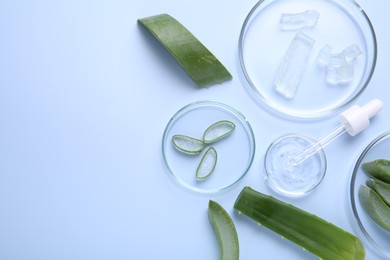 Photo of Flat lay composition with aloe vera leaves and cosmetic gel on light blue background