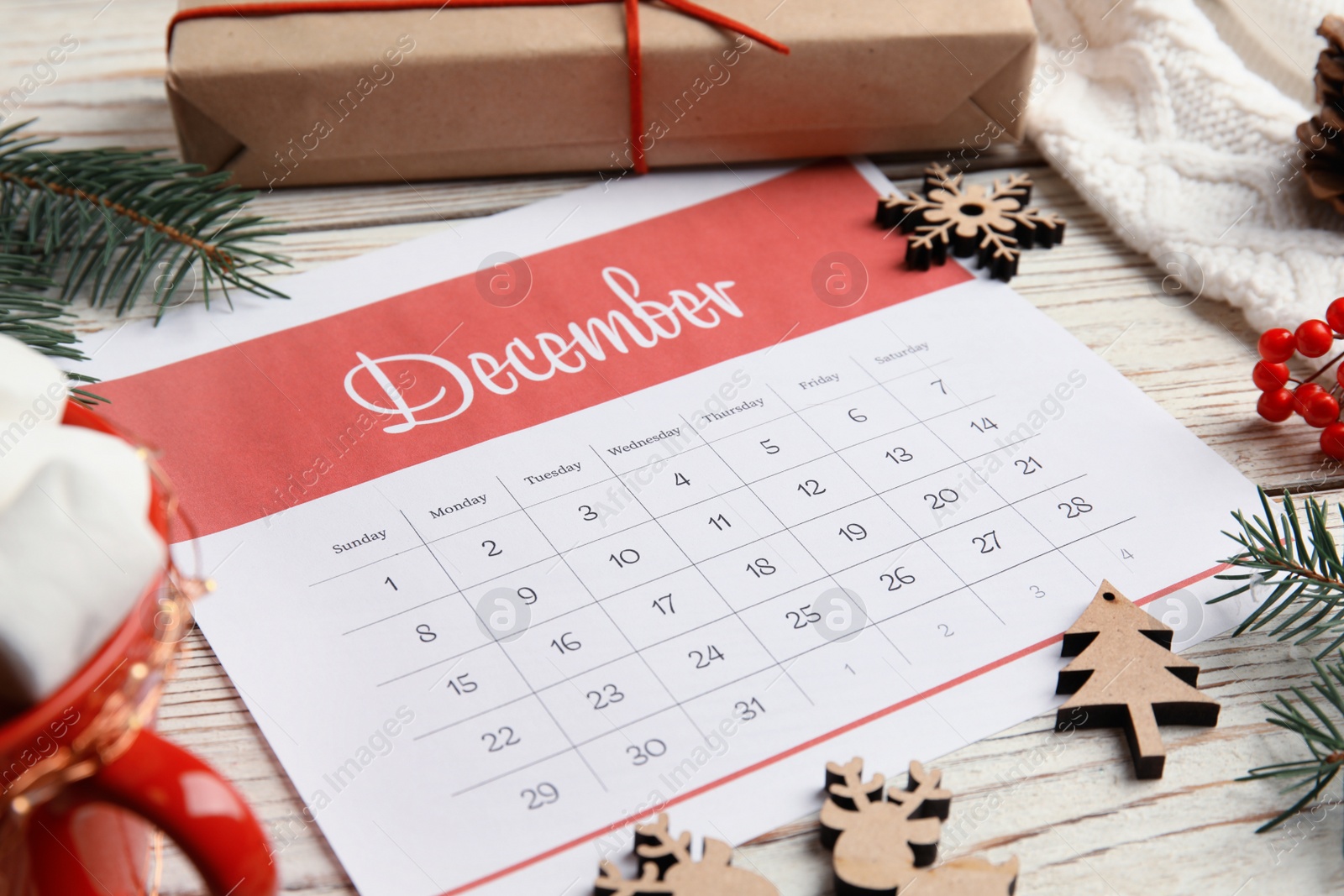 Photo of Paper calendar and festive decor on wooden table