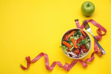 Photo of Measuring tape, vegetable salad and apple on yellow background, flat lay with space for text. Weight loss concept