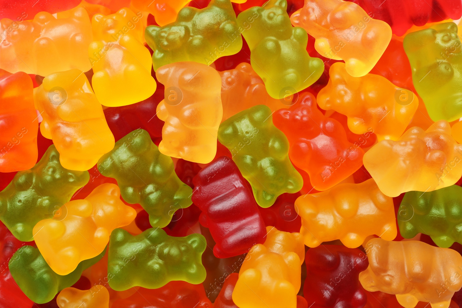 Photo of Delicious bright jelly bears as background, top view