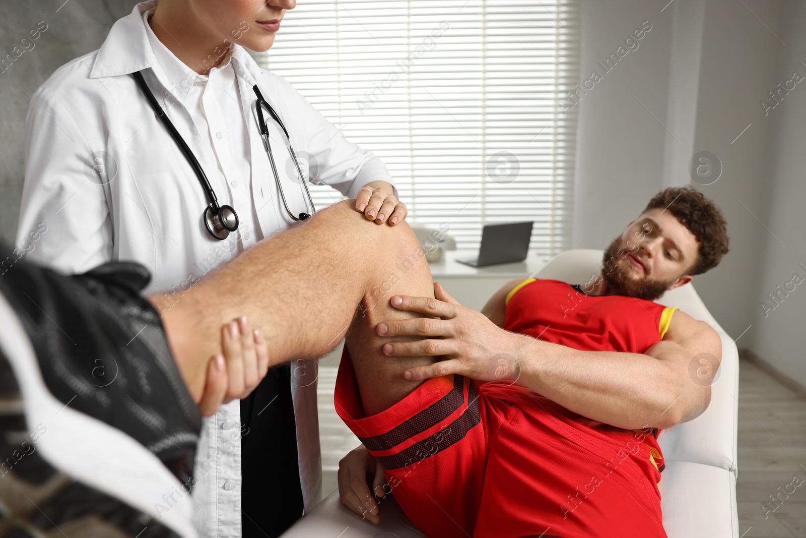 Photo of Sports injury. Doctor examining patient's leg in hospital