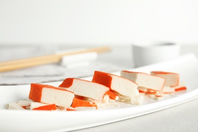 Photo of Fresh delicious crab sticks served on white plate, closeup