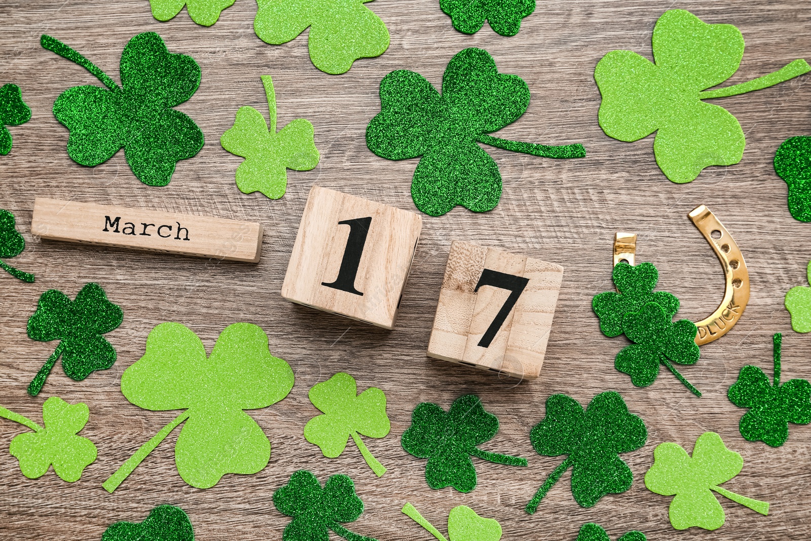 Photo of Flat lay composition with block calendar on grey wooden table. Saint Patrick's Day celebration