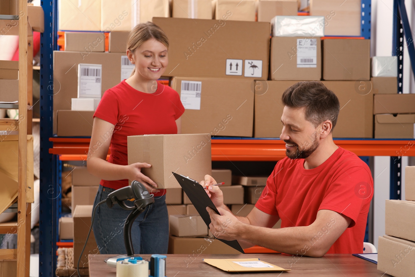 Photo of Post office workers checking parcel barcode indoors