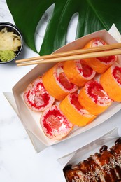 Delicious sushi served on white marble table, flat lay. Food delivery