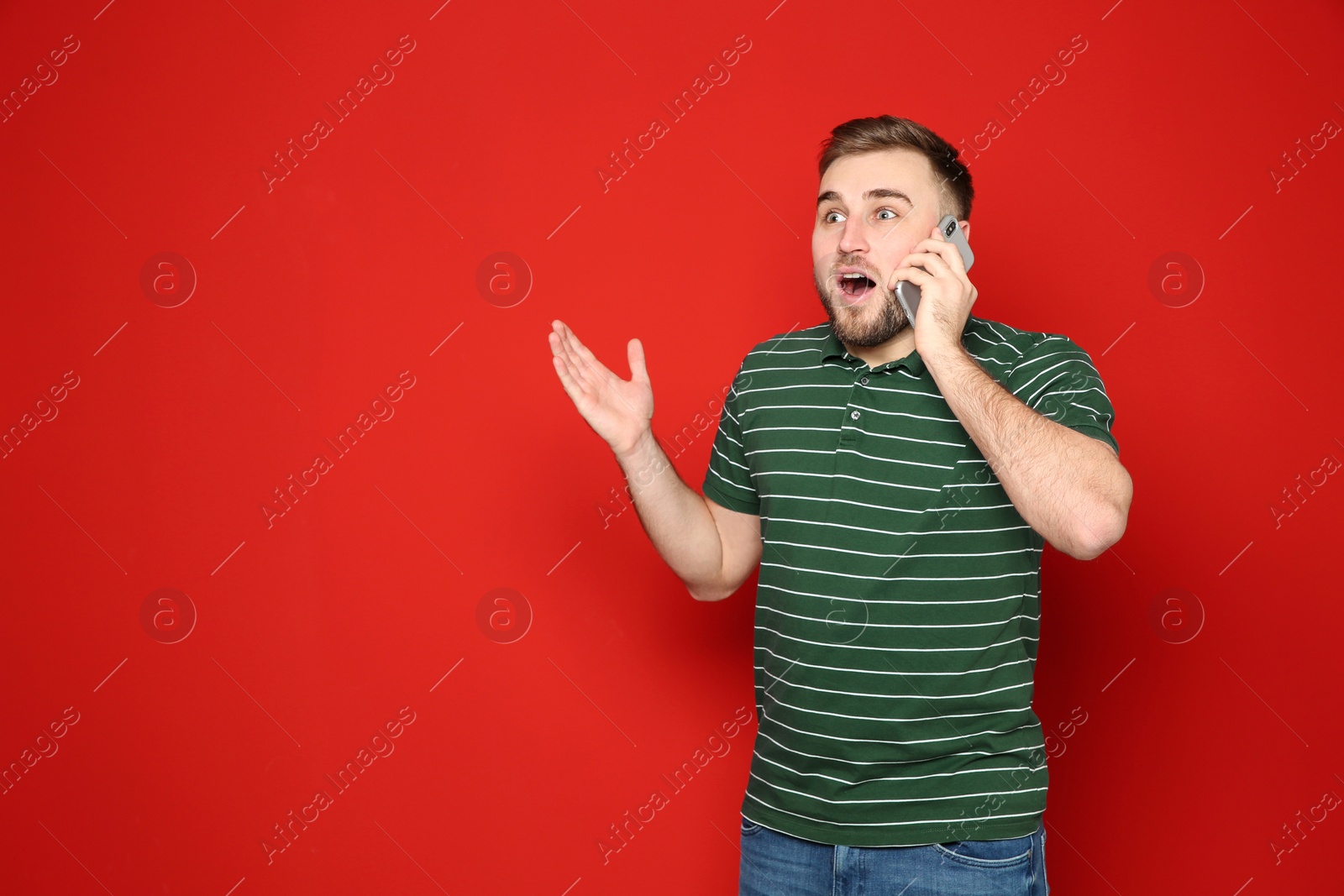 Photo of Portrait of emotional man talking on phone against color background. Space for text