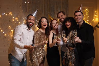Photo of Happy friends with glassessparkling wine celebrating birthday indoors
