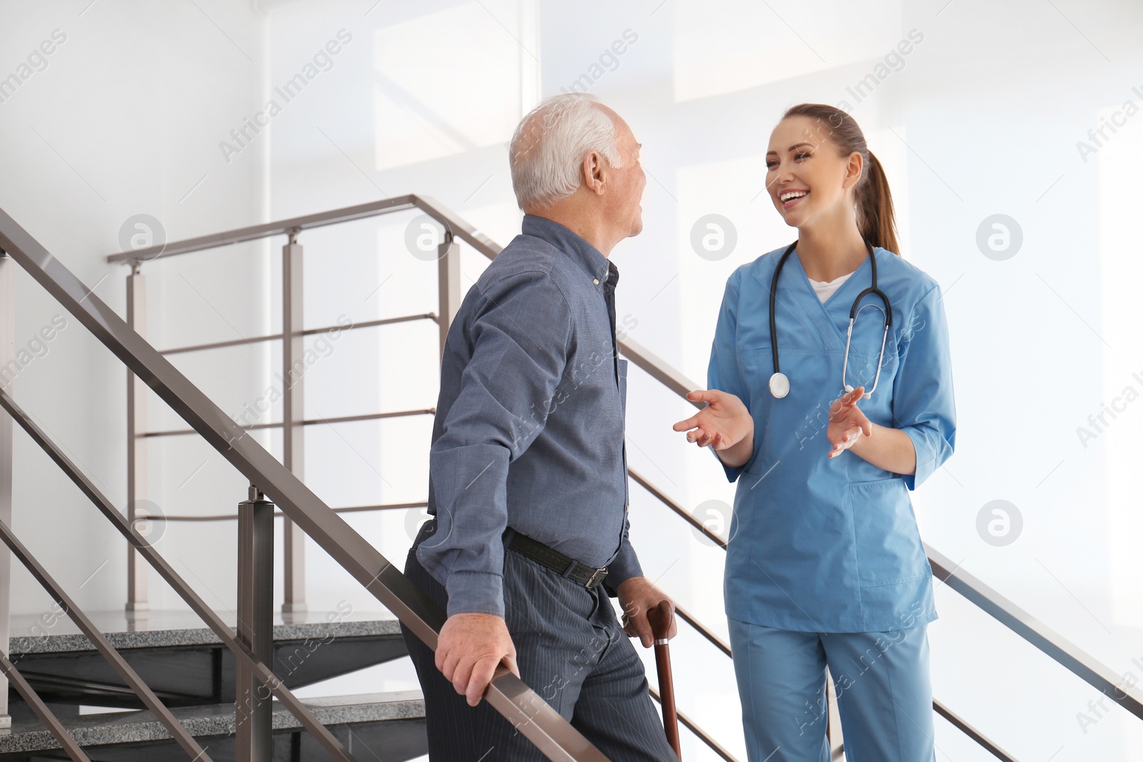 Photo of Doctor helping senior patient in modern hospital