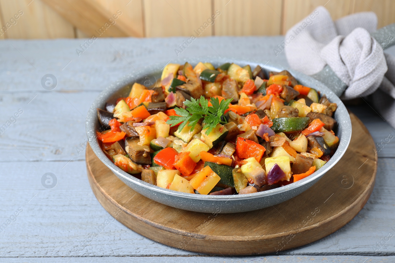 Photo of Delicious ratatouille in frying pan on grey wooden table, closeup